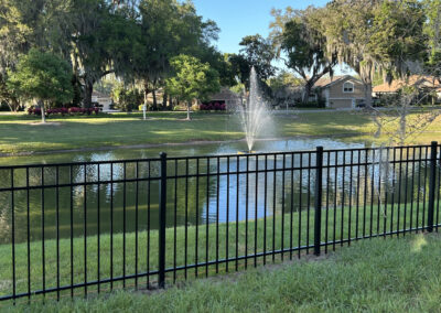 Aluminum fencing installed in the backyard, creating a secure and stylish barrier between the property and a scenic pond.