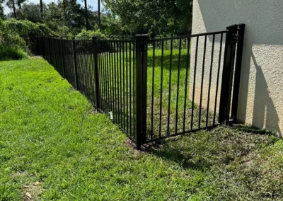 Aluminum fencing connecting to the home of our customer and a gate at the entrance.