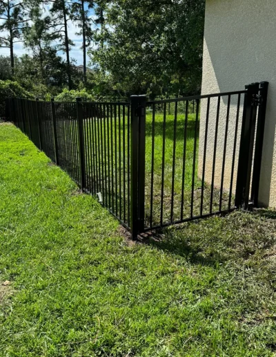 Aluminum fencing connecting to the home of our customer and a gate at the entrance.